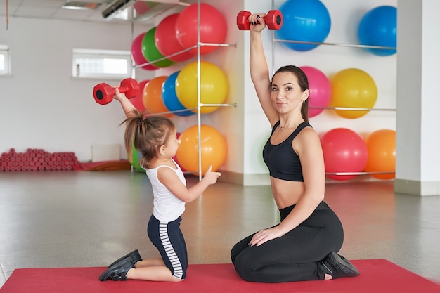 Mãe e filho de fitness. Atividades esportivas com crianças. Academia.