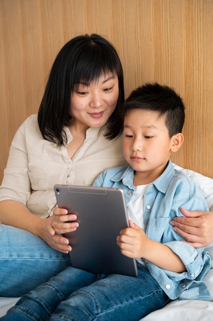 Foto mãe e filho de tiro médio com tablet