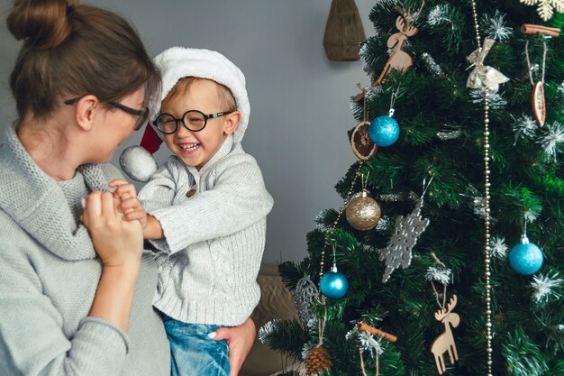 Mãe e filho decoram a árvore de natal juntas