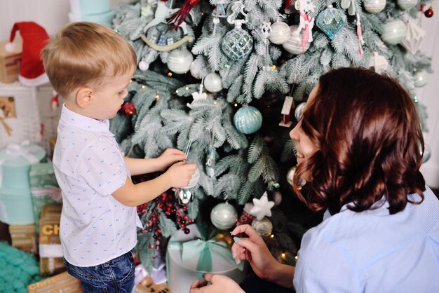 Mãe e filho decoram a árvore em uma casa aconchegante