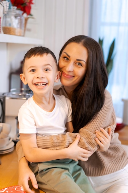 Mãe e filho divertidos a brincar na cozinha, felizes a passar o tempo na véspera de natal e na véspera de ano novo.