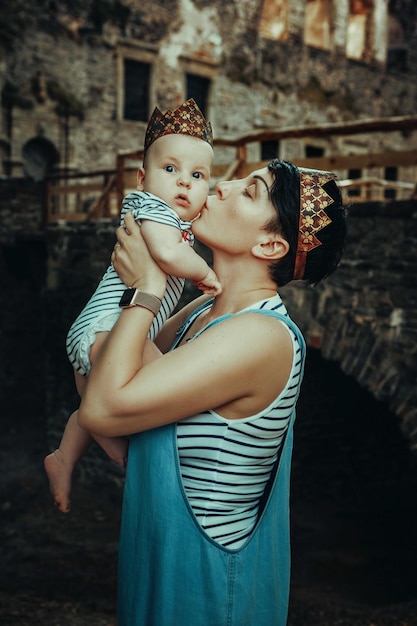 mãe e filho em coroas no fundo de um antigo castelo. Príncipe e Rainha