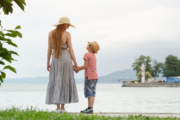 Mãe e filho em pé no cais e se entreolham