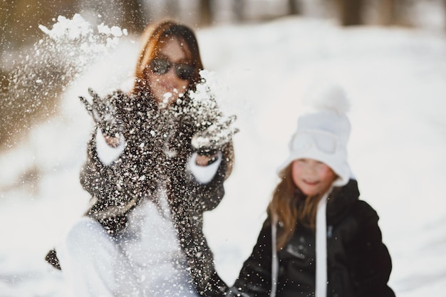 Mãe e filho em roupas de inverno brincando no parque de inverno