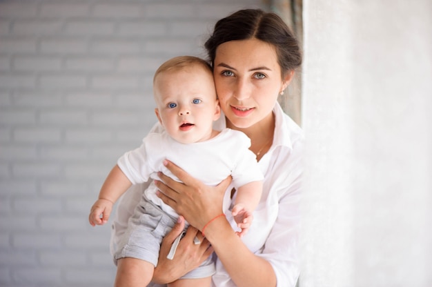 Foto mãe e filho em uma sala branca. mãe, e, menino bebê, em, fralda