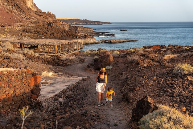 Mãe e filho em uma trilha ao pôr do sol na praia de Tacoron em El Hierro Ilhas Canárias