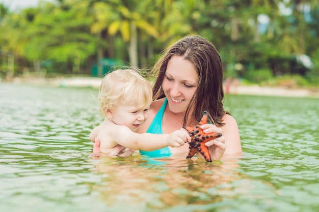 Mãe e filho encontraram uma estrela do mar vermelha no mar