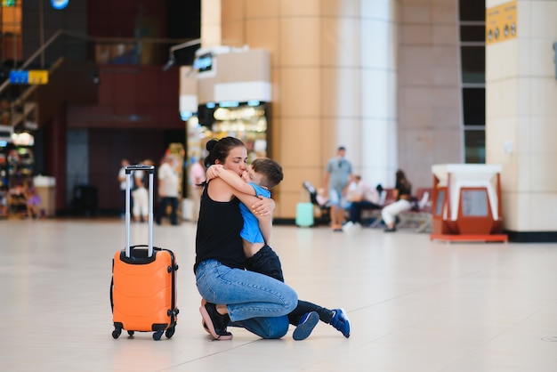 Mãe e filho esperando para embarcar no portão de embarque do moderno terminal internacional.