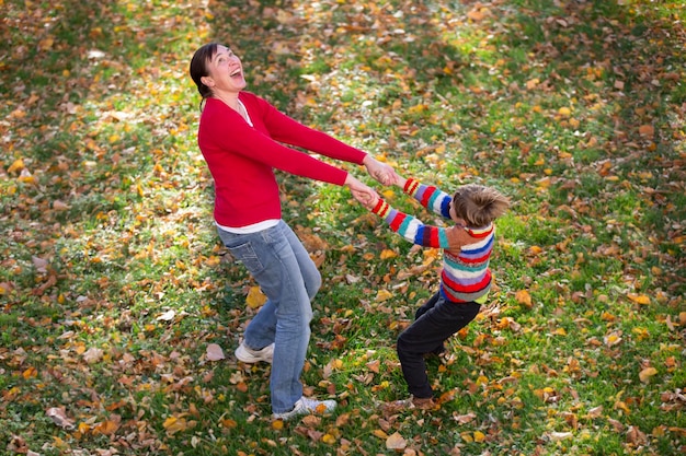 Mãe e filho estão andando no parque outono