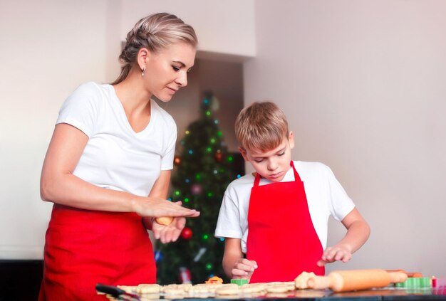 mãe e filho estão cozinhando biscoitos de natal