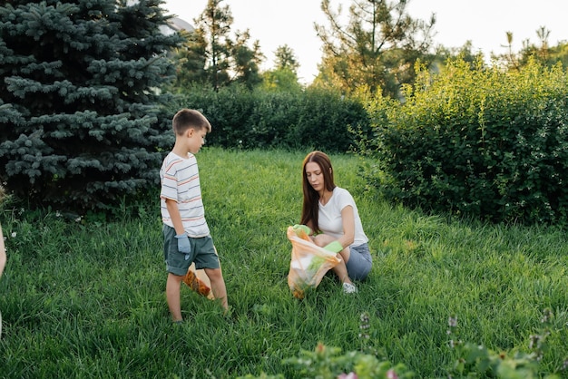 Mãe e filho estão limpando lixo no parque ao pôr do sol Reciclagem de resíduos de cuidados ambientais