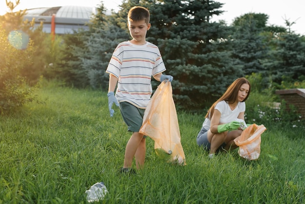 Mãe e filho estão limpando lixo no parque ao pôr do sol Reciclagem de resíduos de cuidados ambientais