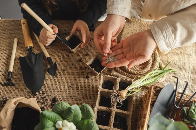 Mãe e filho estão semeando sementes primavera e conceito de jardinagem