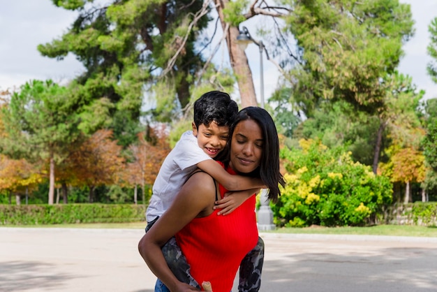 Mãe e filho felizes a divertir-se juntos ao ar livre num parque