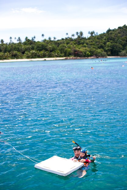 Foto mãe e filho felizes com snorkel e se divertindo na água do oceano, mergulhando com snorkel nas férias do caribe na tailândia