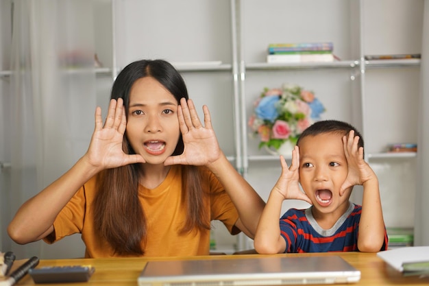 mãe e filho felizes na secretária de casa