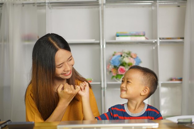 mãe e filho felizes na secretária de casa