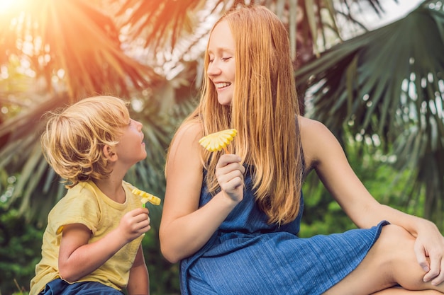 Mãe e filho fizeram um piquenique no parque. Coma frutas saudáveis - manga, abacaxi e melão. As crianças comem alimentos saudáveis