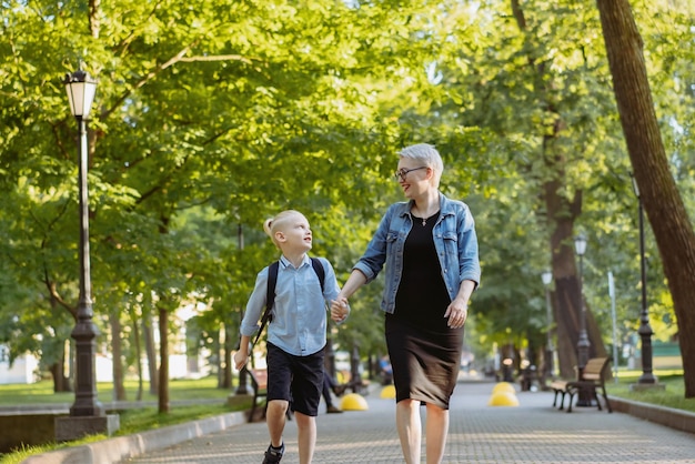 Mãe e filho indo para a escola de mãos dadas