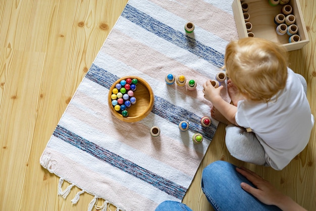 Mãe e filho jogando jogo educacional gnomos em barris usam o método maria montessori de desenvolvimento