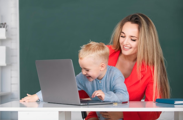 Mãe e filho juntos usando computador portátil pequeno filho de escola usando laptop com a mãe