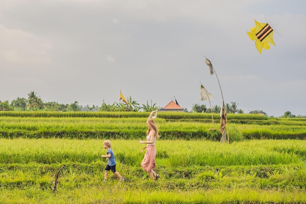 Mãe e filho lançam uma pipa em um campo de arroz em Ubud, Bali Island, Indonésia