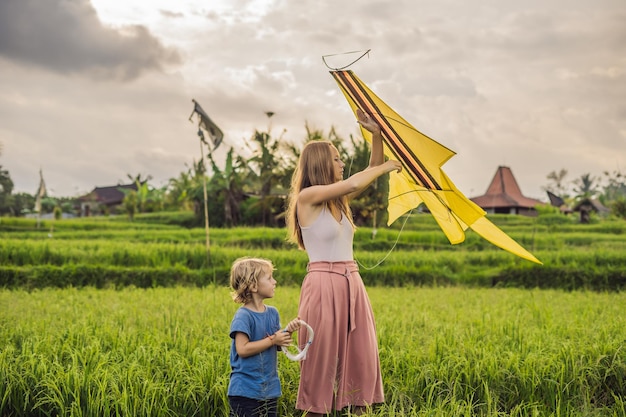 Mãe e filho lançam uma pipa em um campo de arroz em Ubud Bali Island Indonésia