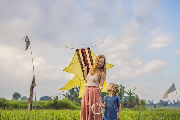 Mãe e filho lançam uma pipa em um campo de arroz em Ubud Bali Island Indonésia