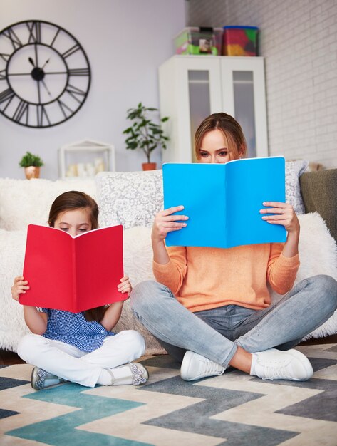 Mãe e filho lendo um livro na sala de estar