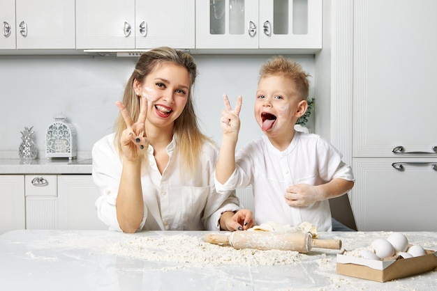 Mãe e filho manchados de farinha e brincando