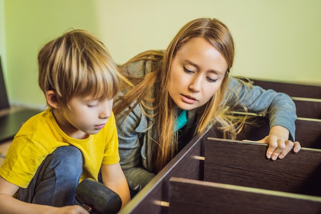 Mãe e filho montando móveis Menino ajudando sua mãe em casa Conceito de família feliz