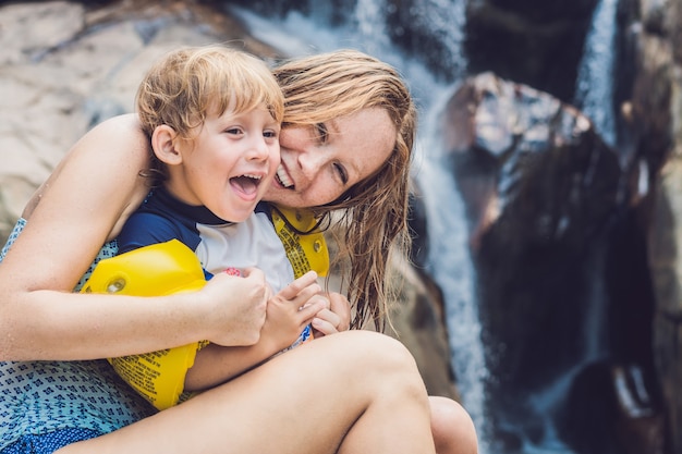 Mãe e filho na cachoeira. Viajar com o conceito de crianças.
