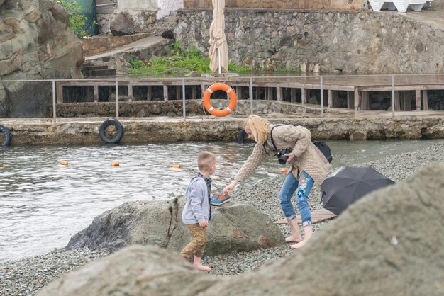 Mãe e filho na praia em tempo nublado