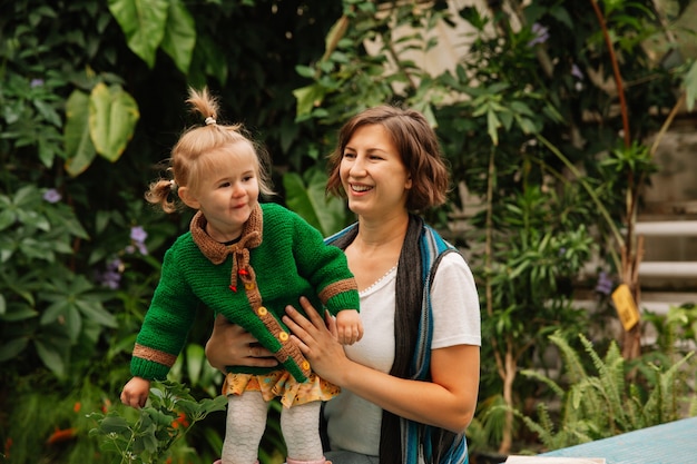 Mãe e filho no jardim botânico. mulher com uma menina no parque.