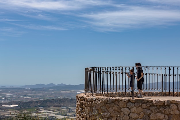 mãe e filho olhando da varanda com grade e vista panorâmica