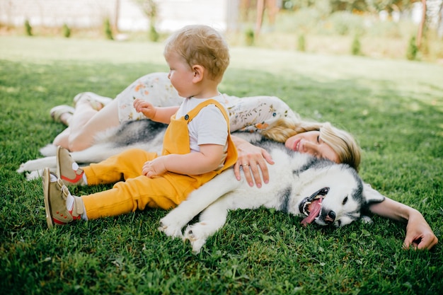 Mãe e filho posando com um cachorro na grama