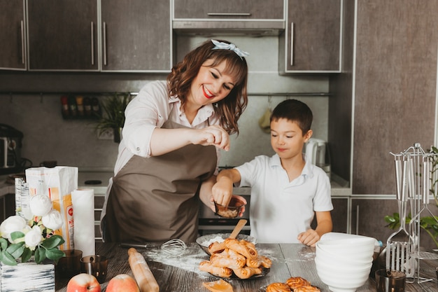 Mãe e filho preparam um bolo de aniversário na cozinha para o Dia das Mães, uma série de fotos do dia a dia no interior da vida real