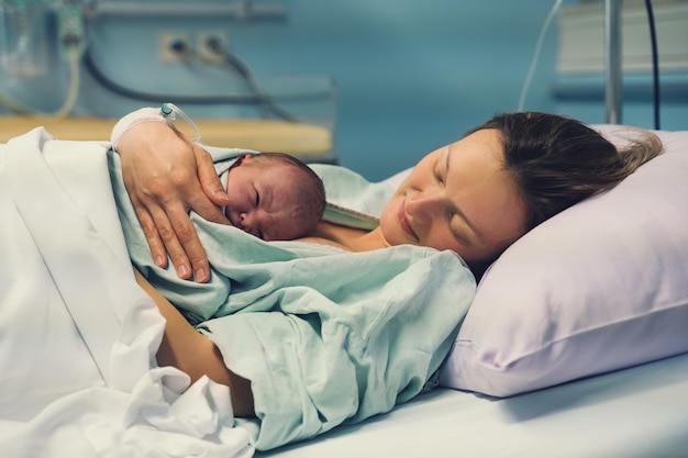 Foto mãe e filho recém-nascido nascimento na maternidade mãe abraçando seu bebê recém-nascido após o parto