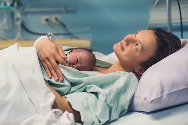Foto mãe e filho recém-nascido nascimento na maternidade mãe abraçando seu bebê recém-nascido após o parto