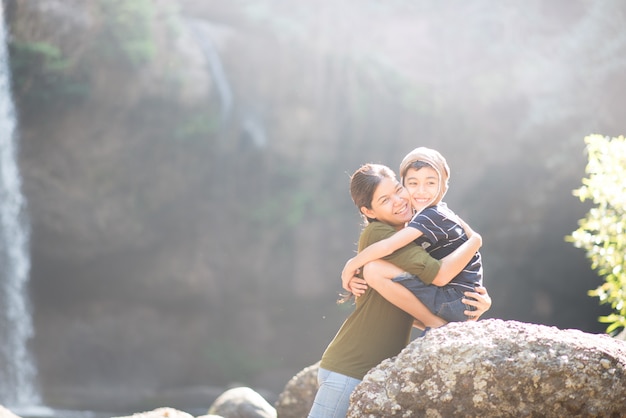 Mãe e filho se abraçam felizes juntos na floresta