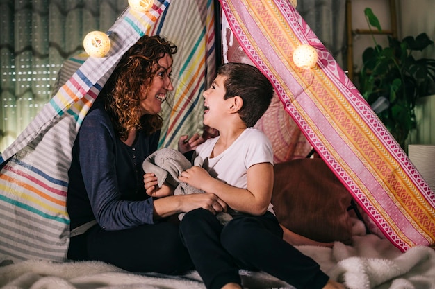 Foto mãe e filho se divertindo em uma tenda em casa