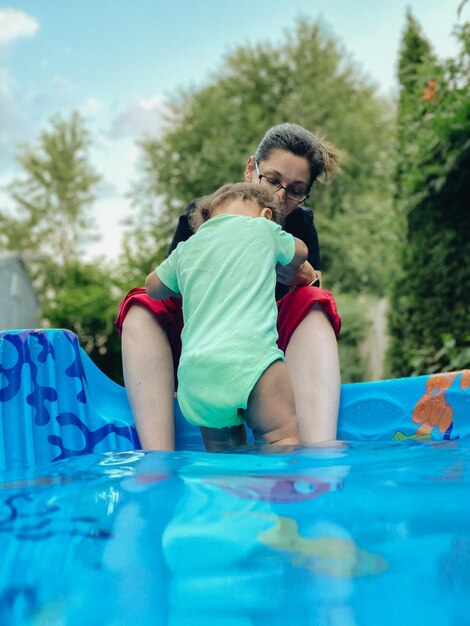 Foto mãe e filho sentados na piscina