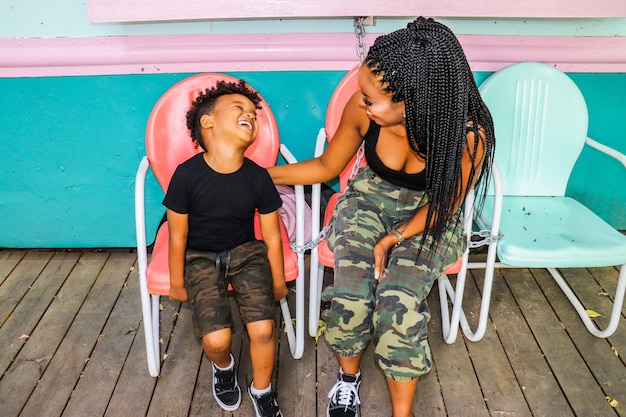 Mãe e filho sorridente sentados em cadeiras