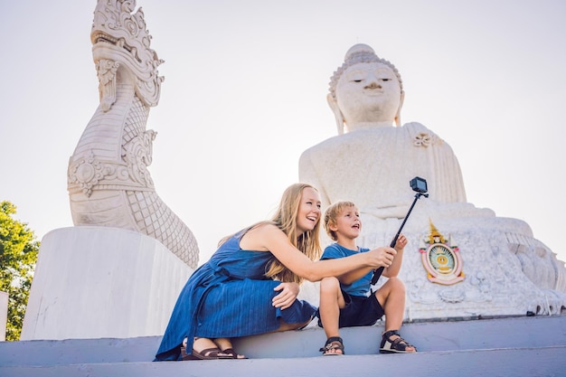 Mãe e filho turistas na grande estátua de Buda foi construída no topo de uma colina alta na cidade de phuket tailândia.