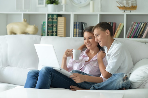 Mãe e filho usando laptop moderno em casa