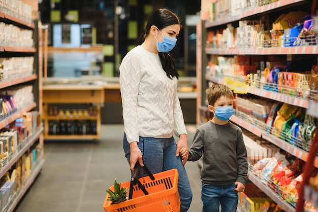Mãe e filho usando máscara protetora em um supermercado