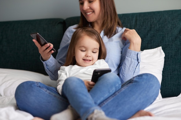 Mãe e filho usando smartphones em casa