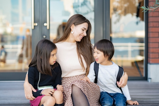 Mãe e filhos brincando com um sorriso ao ar livre