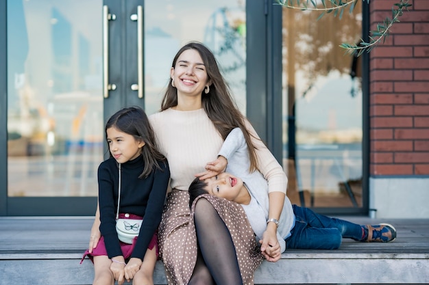 Mãe e filhos brincando com um sorriso ao ar livre