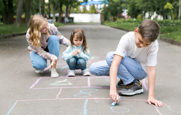 Mãe e filhos brincando de amarelinha